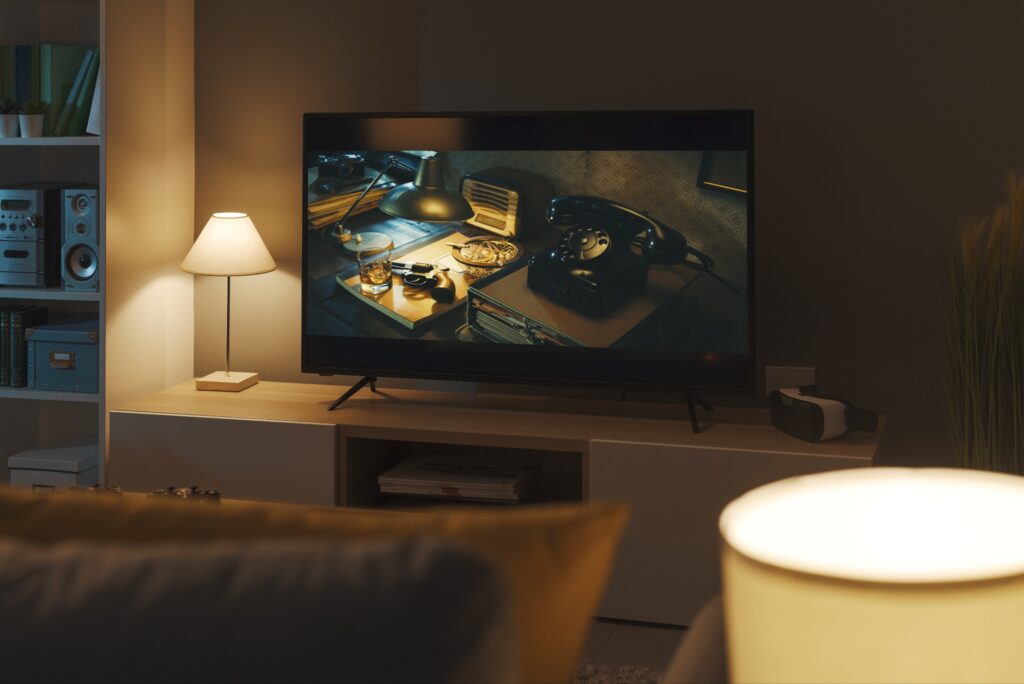 A view of a cozy, dimly-lit living room with a noir scene on the screen.