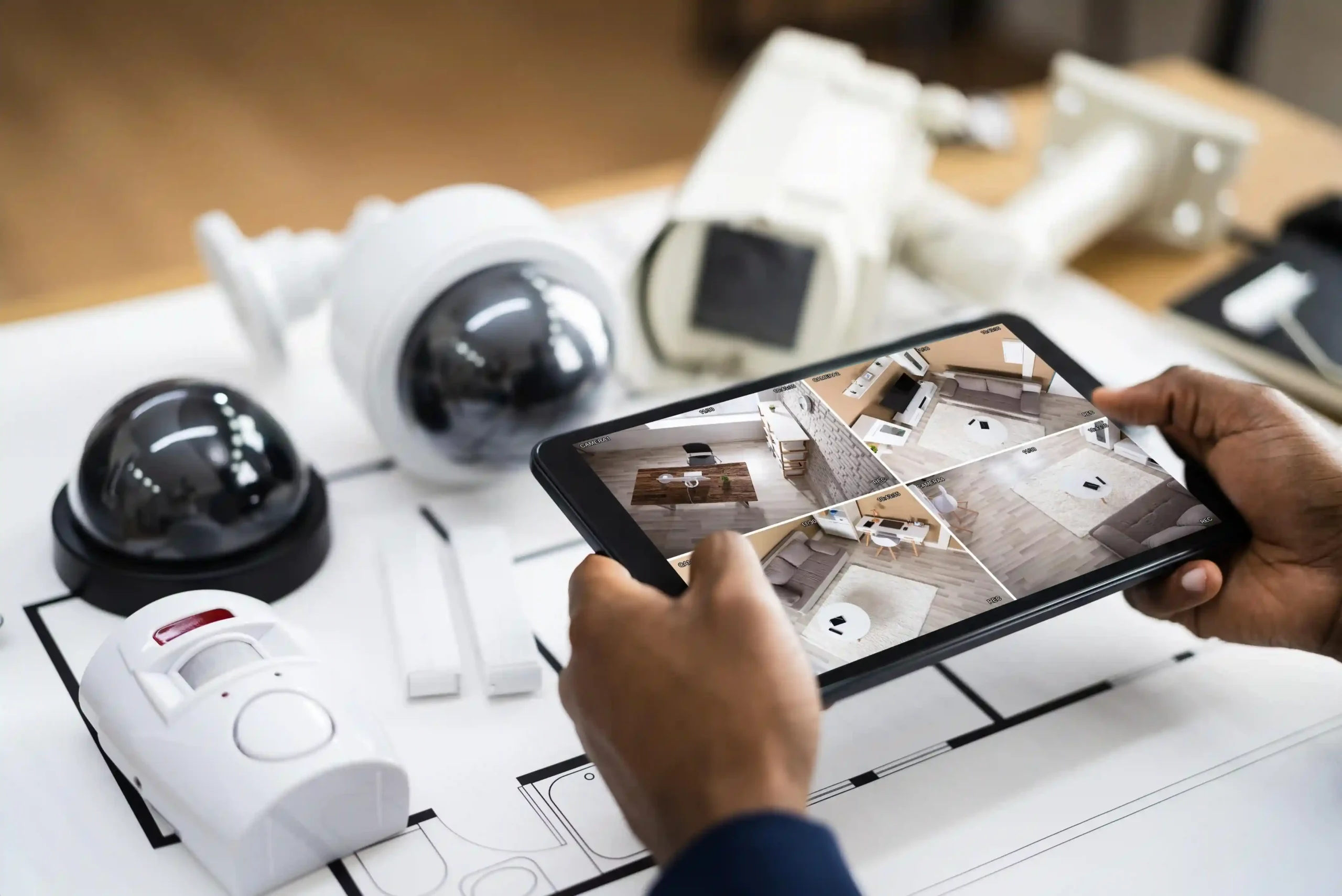 Person checking security camera feed on tablet.