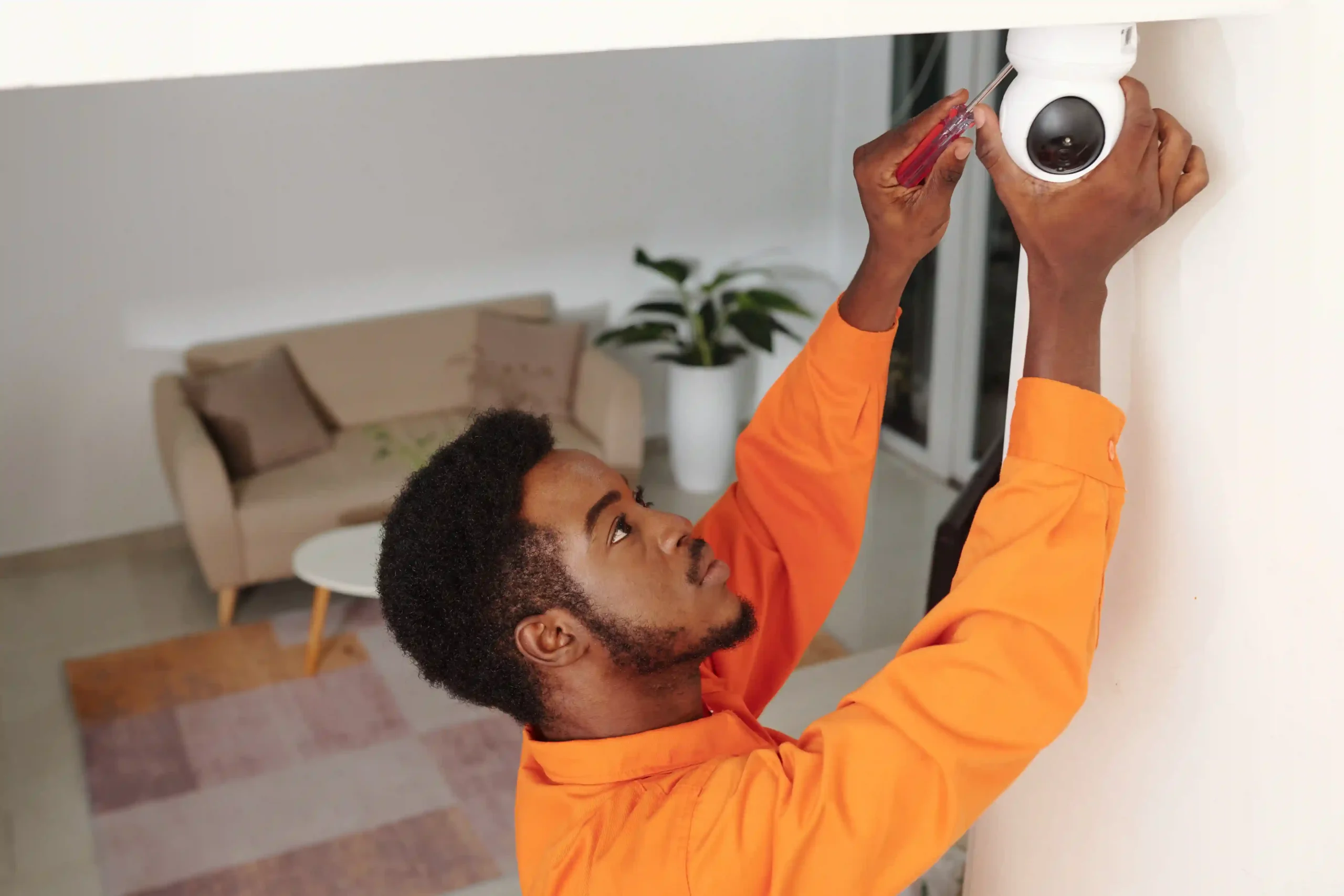 Man installing a security camera indoors.