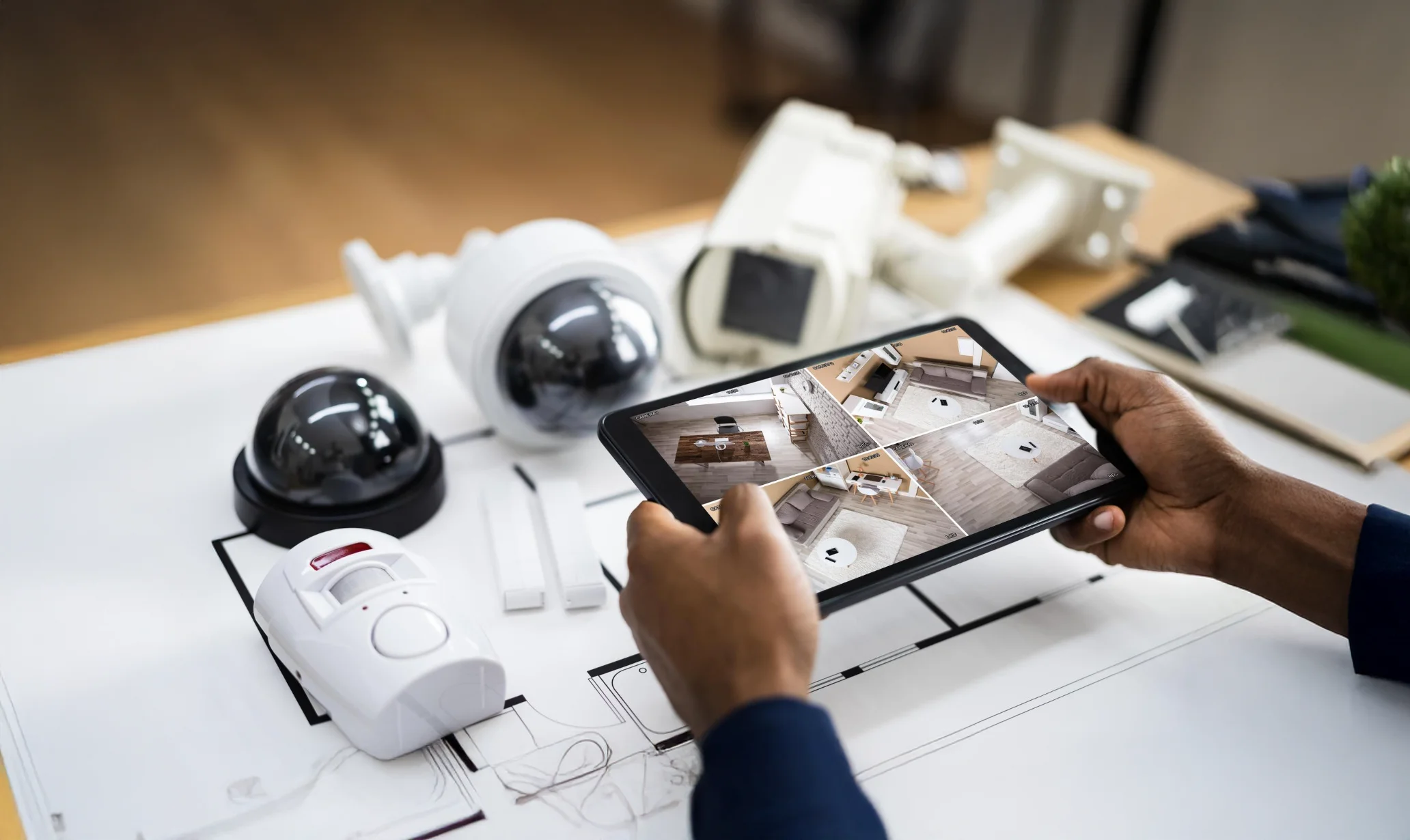 Person using tablet to monitor security cameras.