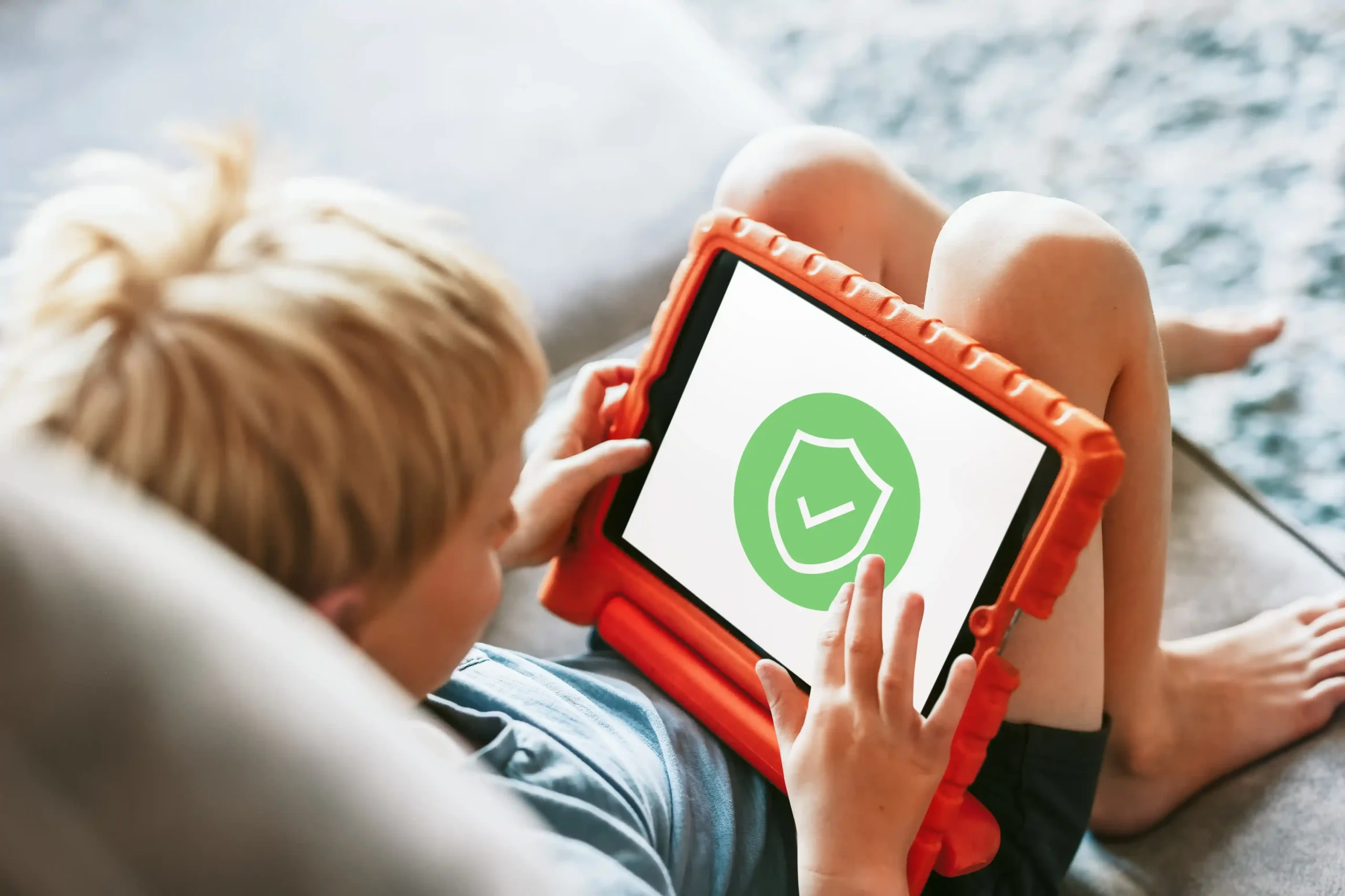 Child using a tablet with a security icon.