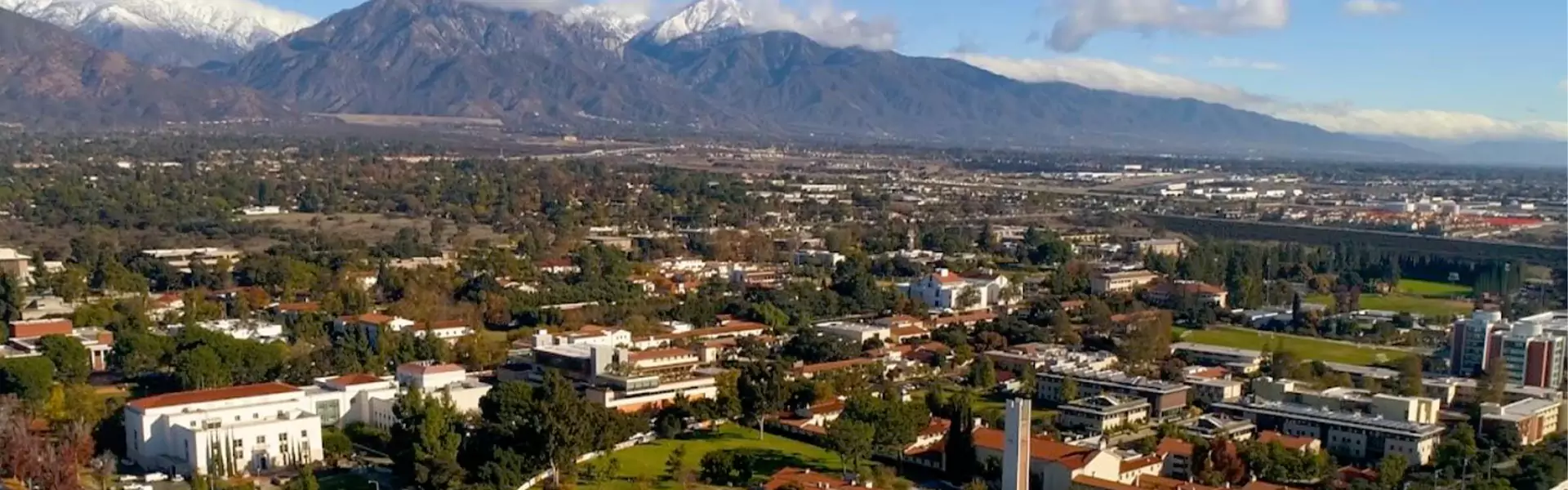 Aerial view of a city with mountains in background.