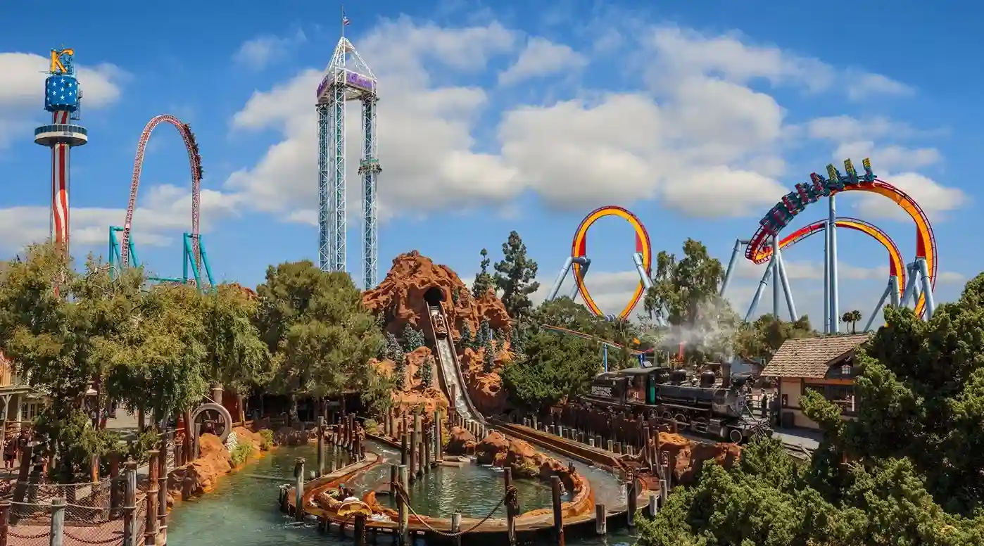 Amusement park attractions with roller coasters and trees.