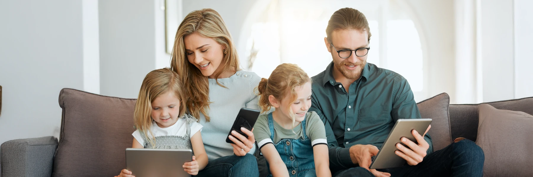 Family using digital devices together at home