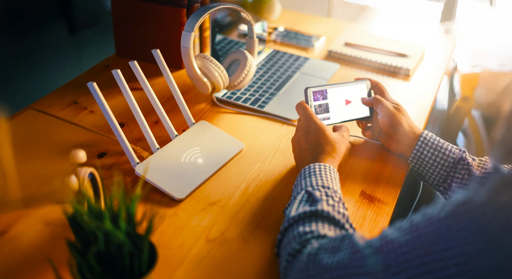 Person browsing a mobile device next to a router.