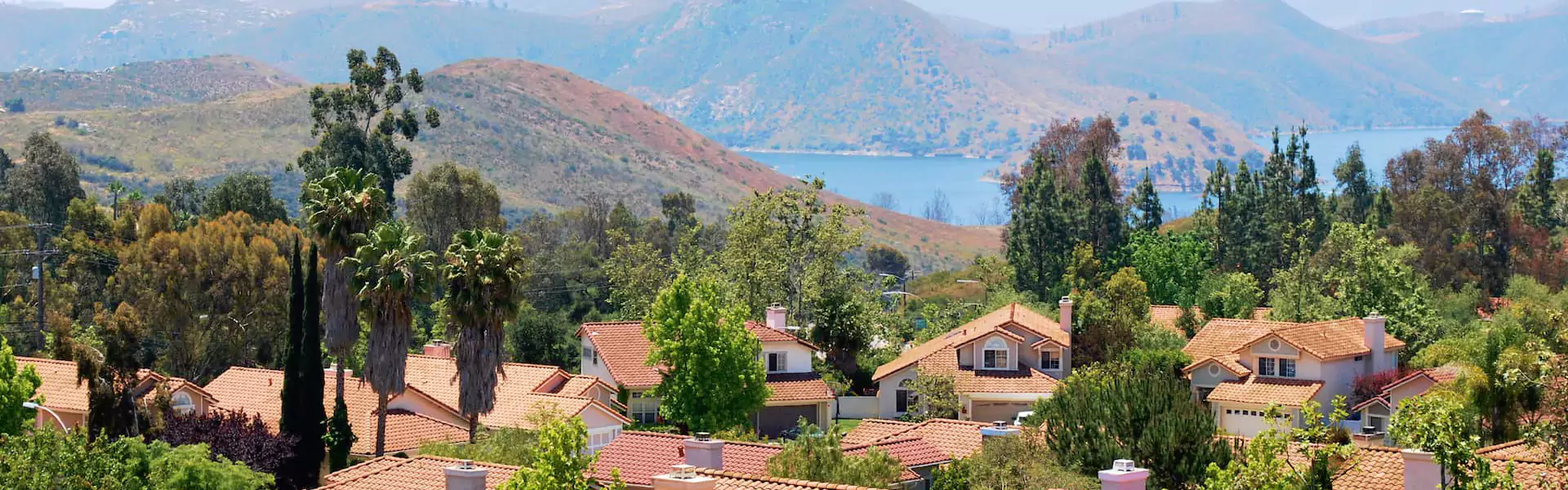 Scenic view of homes and hills by a lake