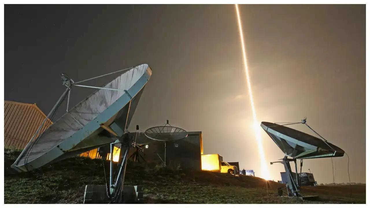 Satellite dishes with rocket launch in background