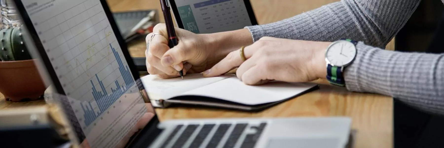 someone with a computer and also maybe some folders or notepads; someone researching, looking focused at the computer