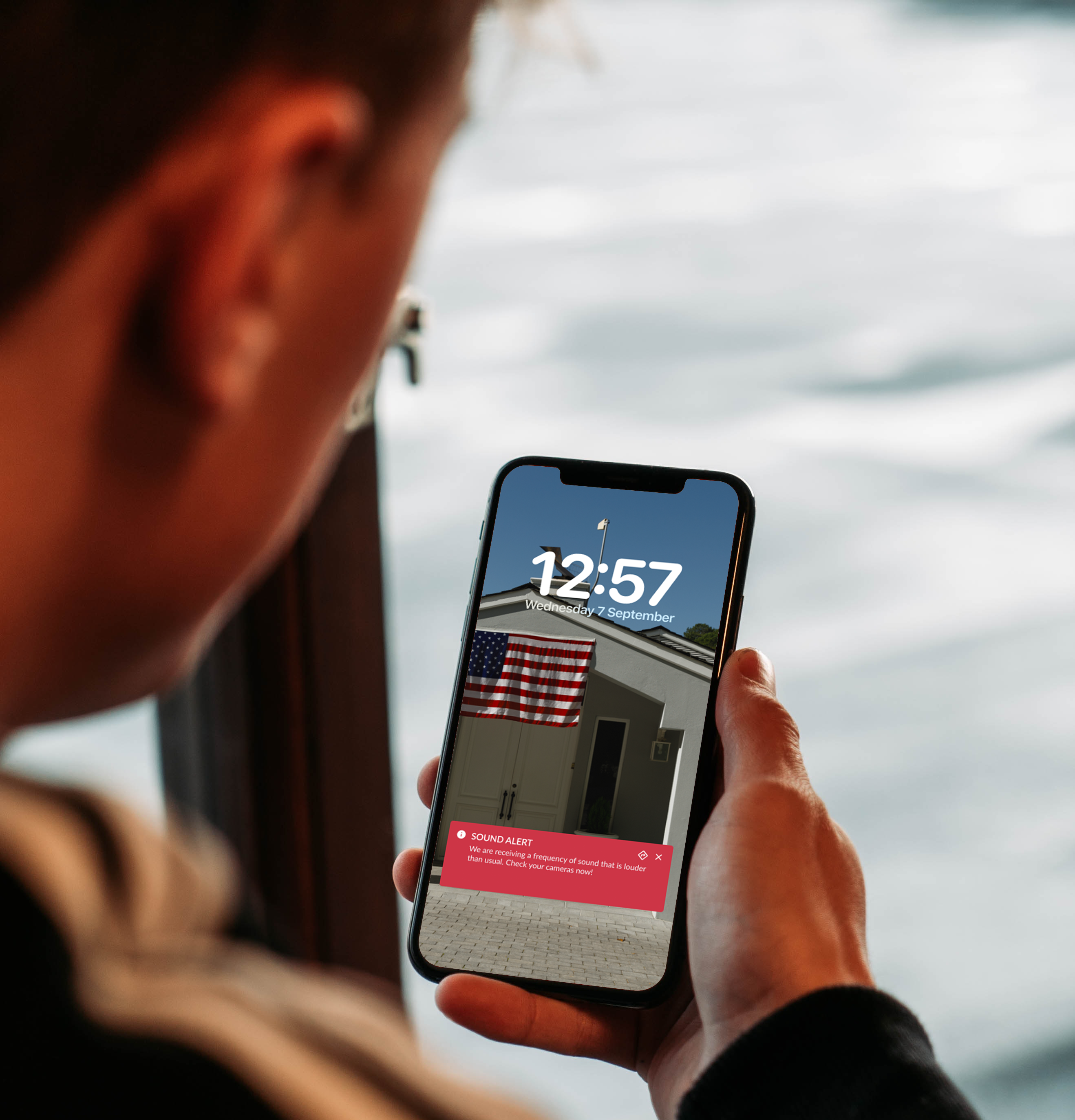 Person holding phone displaying time and alert.