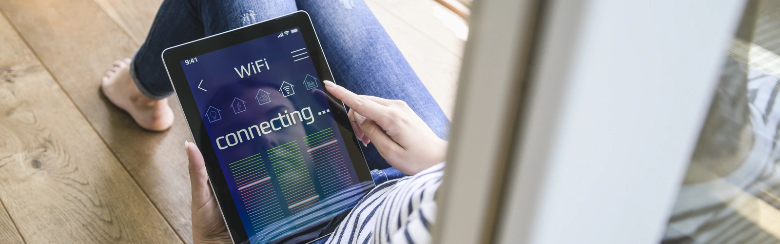 Person using tablet to connect to WiFi.