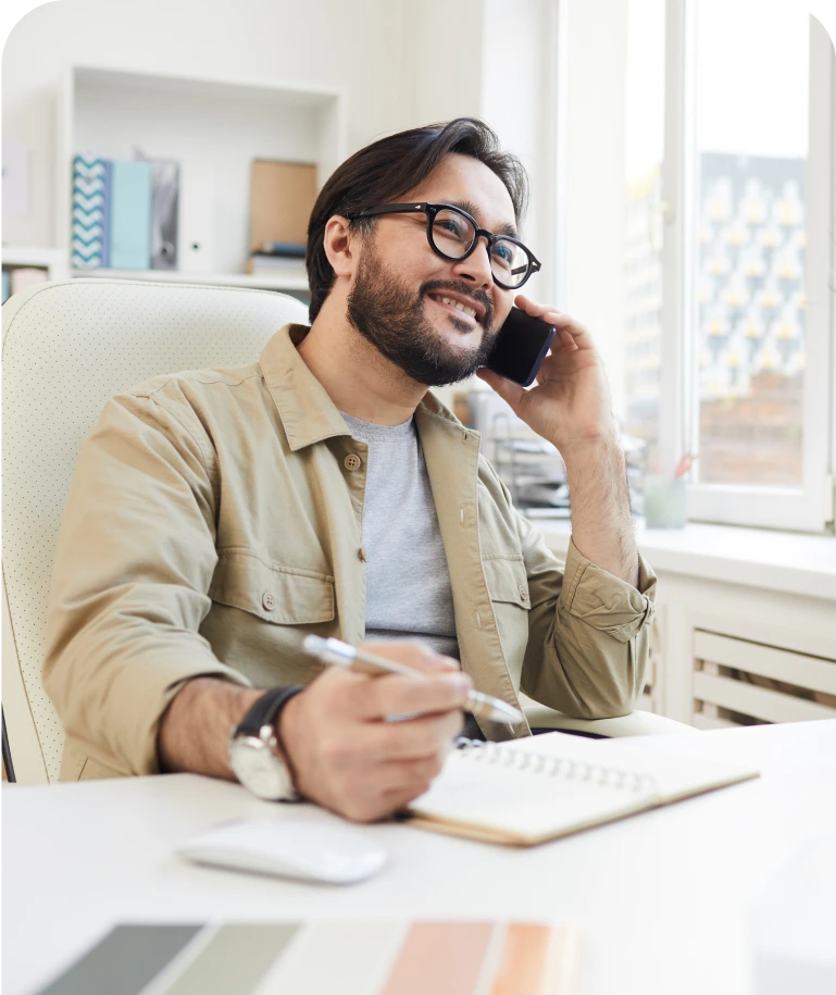 Man talking on phone while taking notes