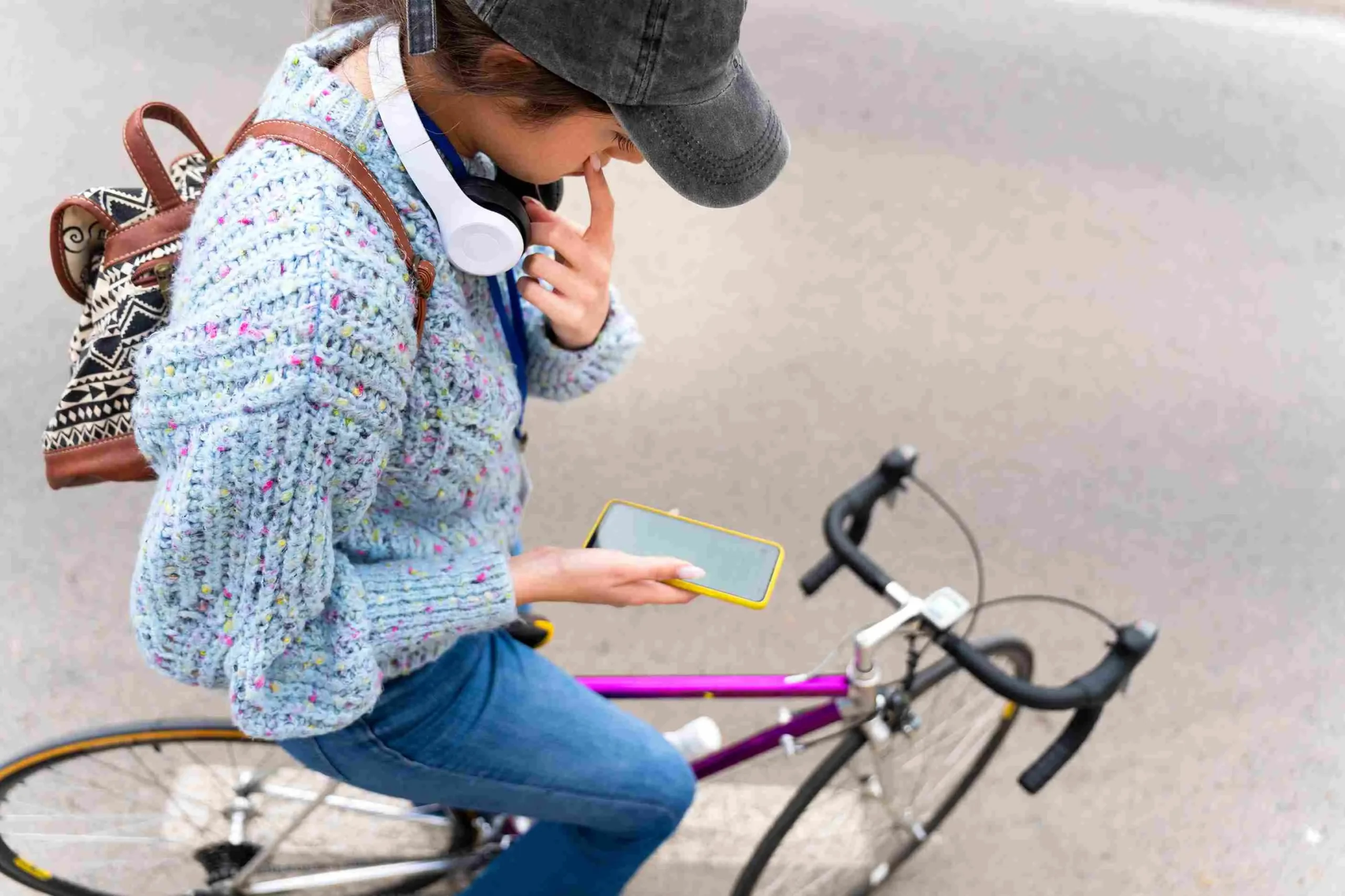 Person checking phone while sitting on bicycle.