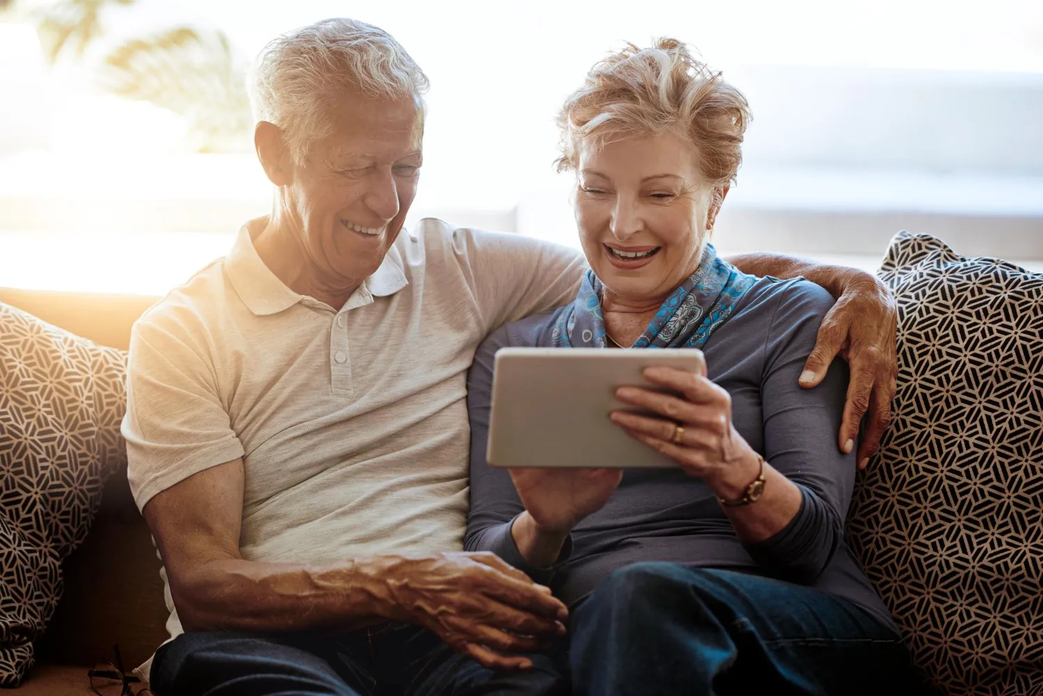 Happy couple enjoying a tablet together at home.