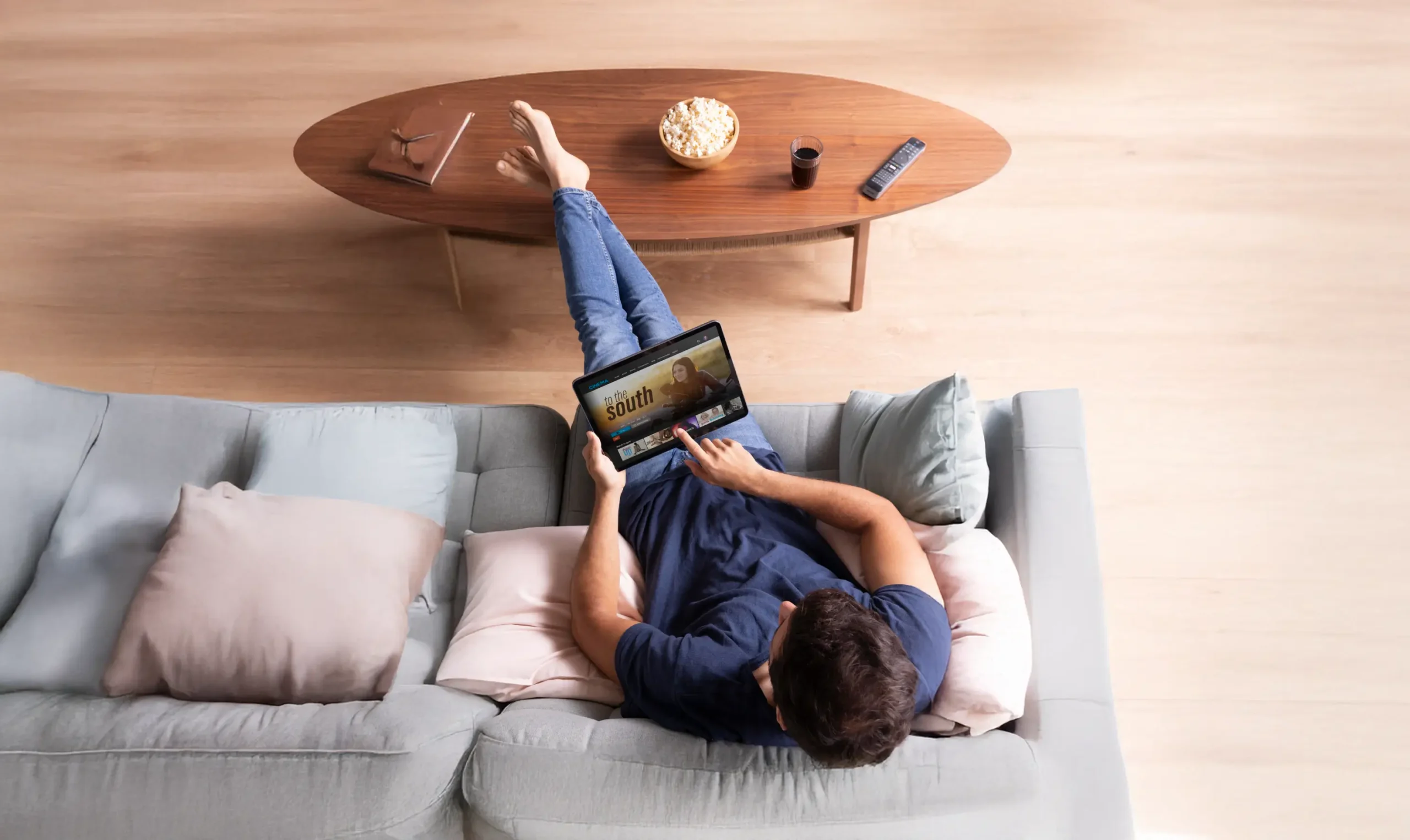 Person relaxing on couch using a tablet.